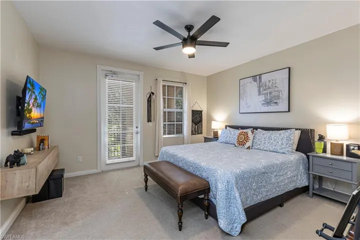 Bedroom with light colored carpet, access to outside, and ceiling fan