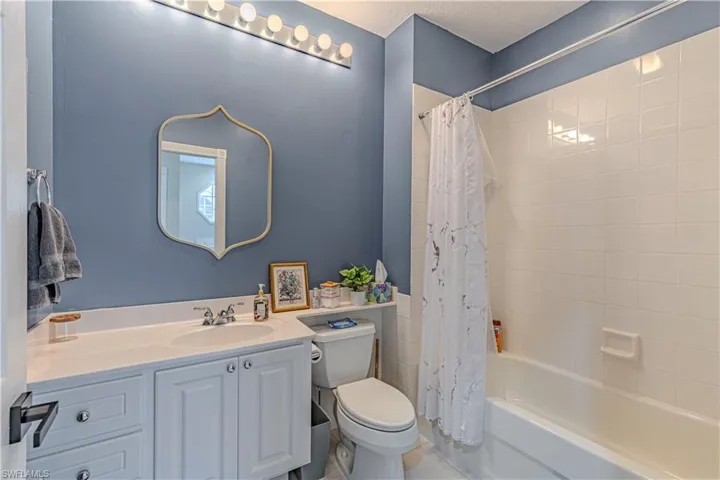 Full bath featuring vanity, shower / tub combo, and a textured ceiling