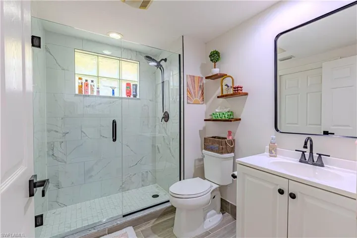 Bathroom with vanity and a marble finish shower