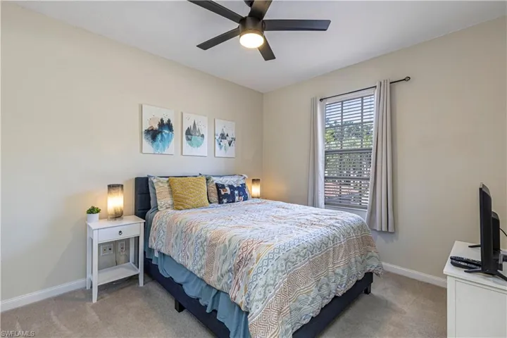 Bedroom featuring light carpet and a ceiling fan