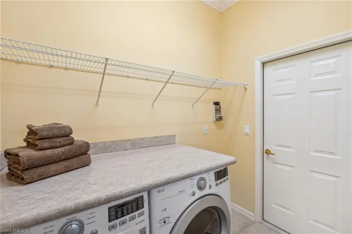 Clothes washing area featuring ornamental molding and washer / clothes dryer