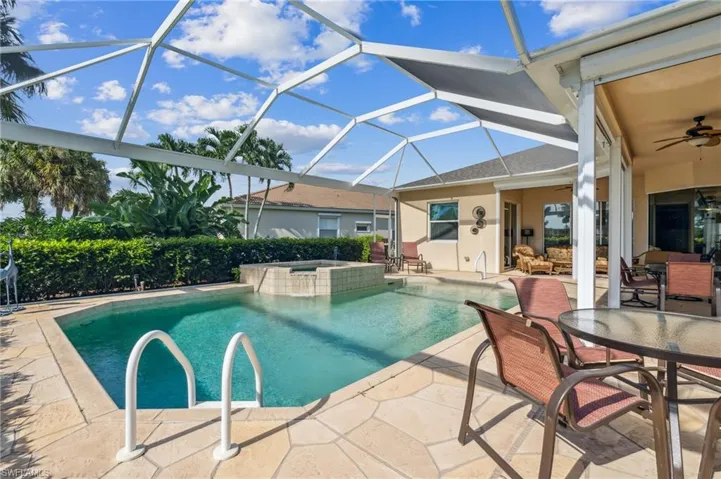View of pool featuring a patio, glass enclosure, ceiling fan, and an in ground hot tub