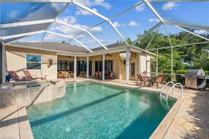 View of pool with a lanai, ceiling fan, and a patio area