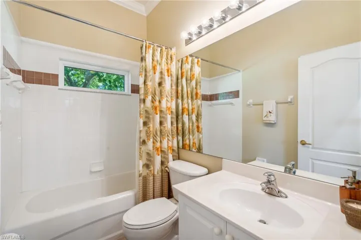Full bathroom featuring ornamental molding, vanity, shower / tub combo, and toilet