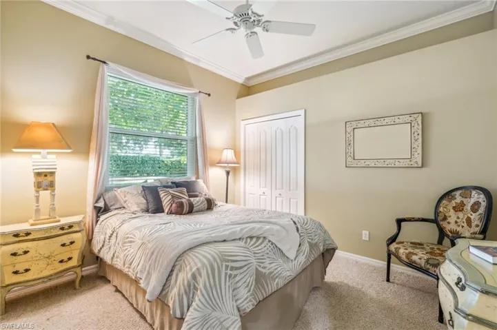 Bedroom featuring ceiling fan, light colored carpet, a closet, and crown molding