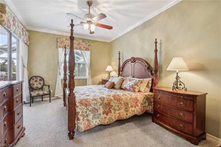 Bedroom featuring ceiling fan, light colored carpet, and crown molding