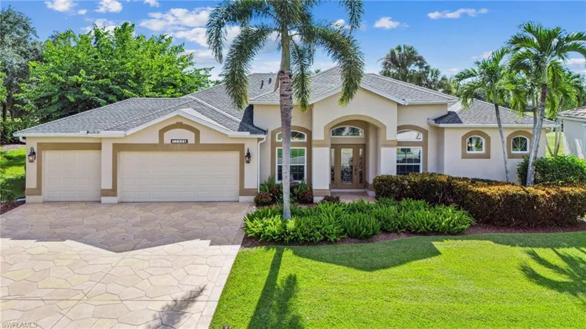 View of front of house featuring a front lawn and a garage