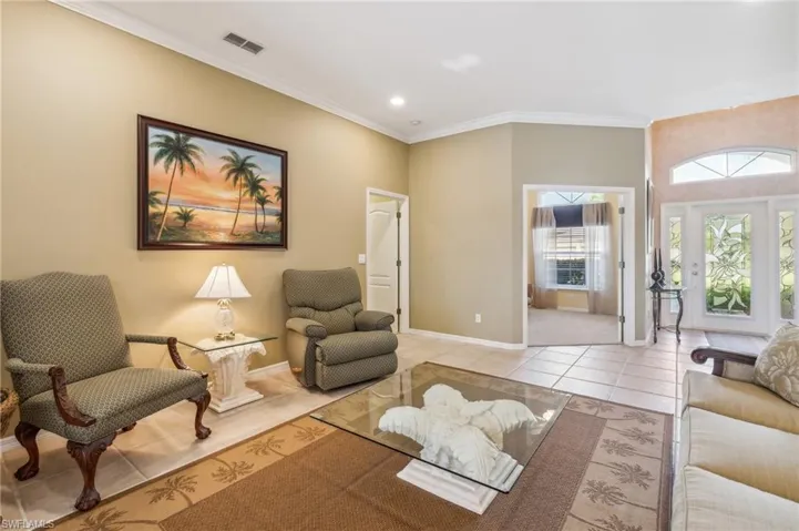 Tiled living room featuring crown molding