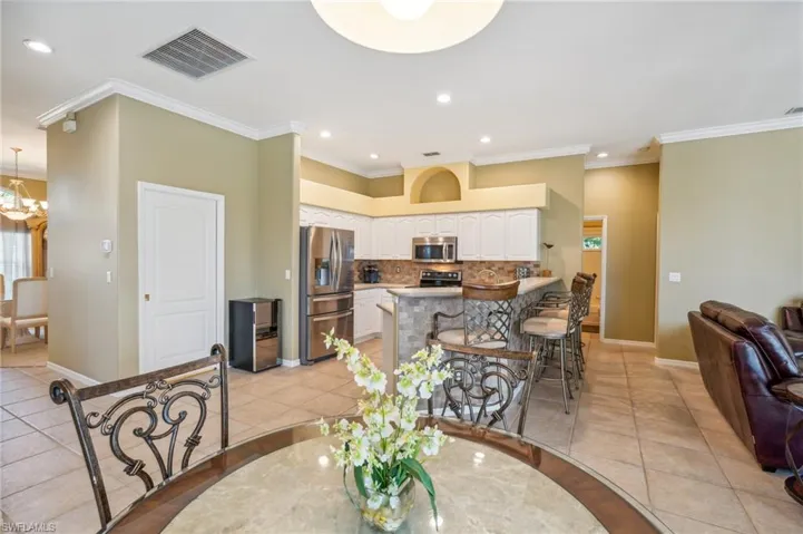 Tiled dining area featuring a chandelier and crown molding