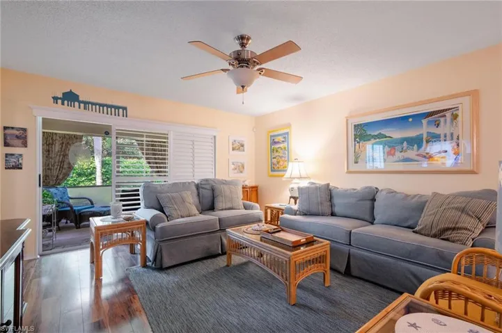 Living room featuring hardwood / wood-style floors, ceiling fan, and a textured ceiling
