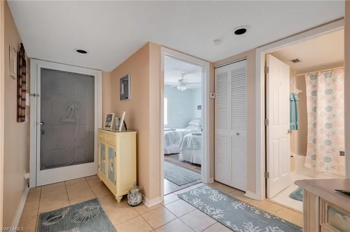 Entrance foyer with a textured ceiling, ceiling fan, and light tile patterned floors