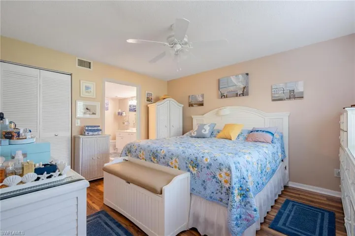 Bedroom with ceiling fan, hardwood / wood-style floors, a closet, and ensuite bath