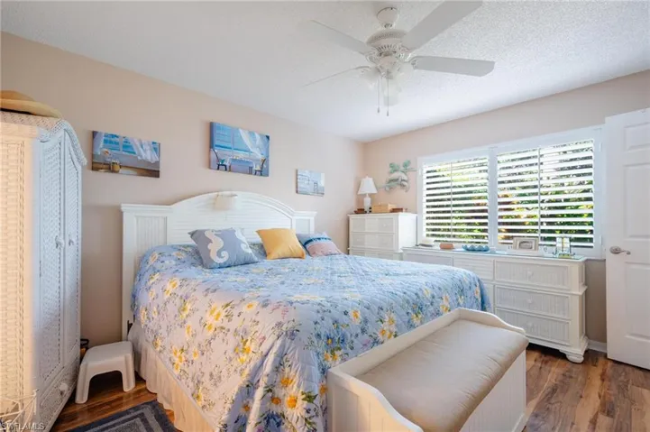 Bedroom featuring ceiling fan, wood-type flooring, and a textured ceiling