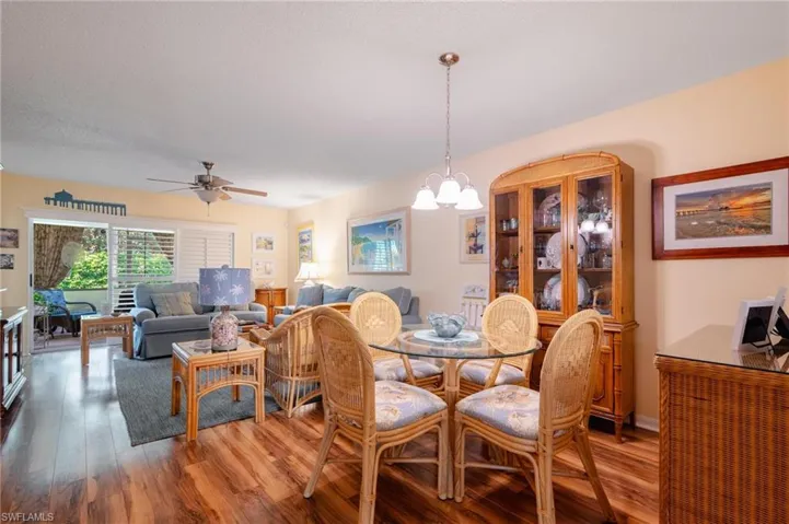 Dining room featuring ceiling fan with notable chandelier and hardwood / wood-style floors