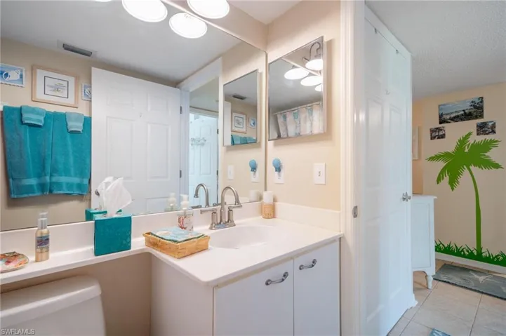 Bathroom with tile patterned floors, toilet, a textured ceiling, and vanity