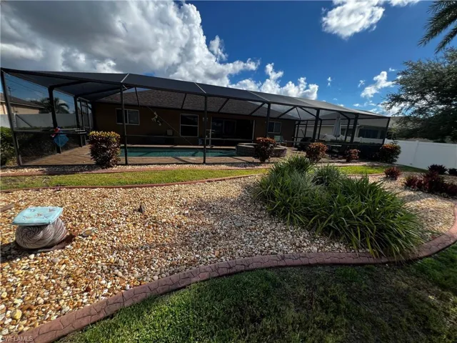 Back of property featuring a sunroom, a fenced backyard, an outdoor pool, and a patio area