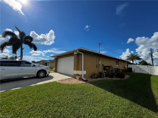 View of property exterior with driveway, a gate, stucco siding, a garage, and a yard
