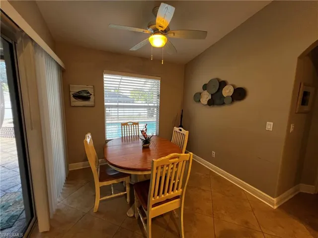 Tiled dining area featuring a ceiling fan and arched walkways