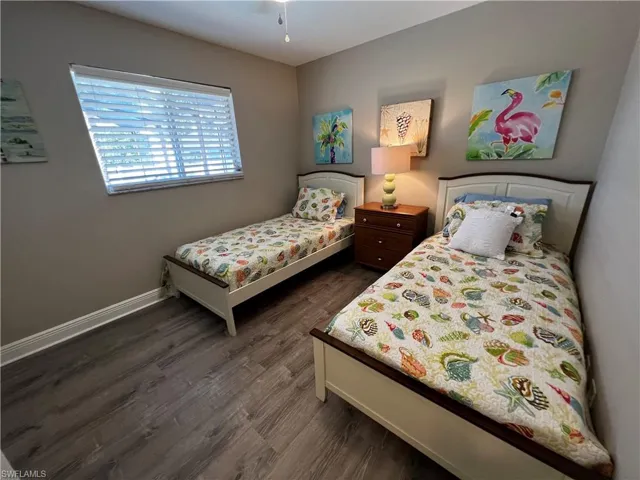 Bedroom with dark wood-style floors and baseboards