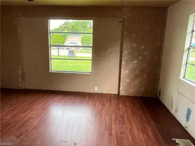 Unfurnished room featuring dark wood-type flooring