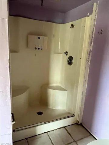 Bathroom with tile patterned floors and a shower