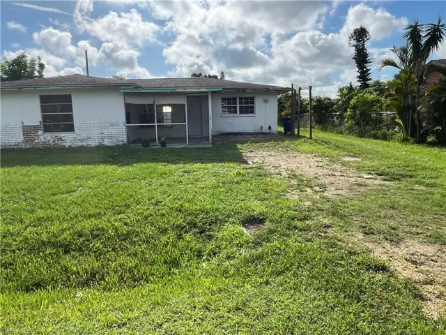 Rear view of property with a lawn