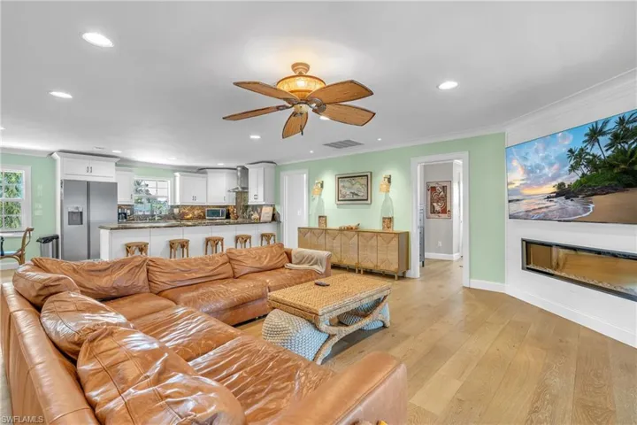 Living room featuring recessed lighting, light wood-style floors, ceiling fan, and crown molding