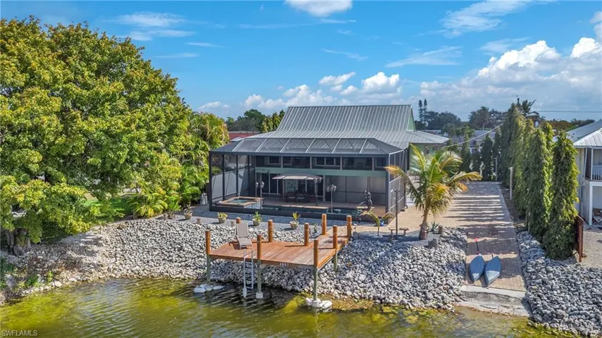 Dock featuring a lanai, a sunroom, an outdoor pool, and a deck with water view