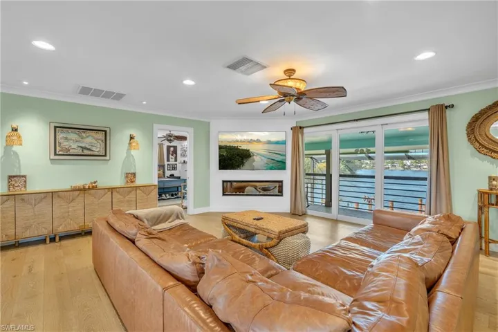 Living area with light wood finished floors, recessed lighting, and crown molding