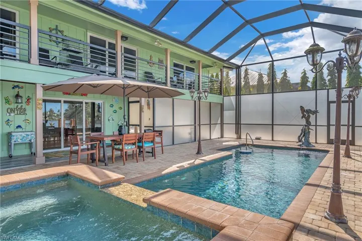 Integrated pool / spa with outdoor dining area, glass enclosure, a sunroom, and a patio area