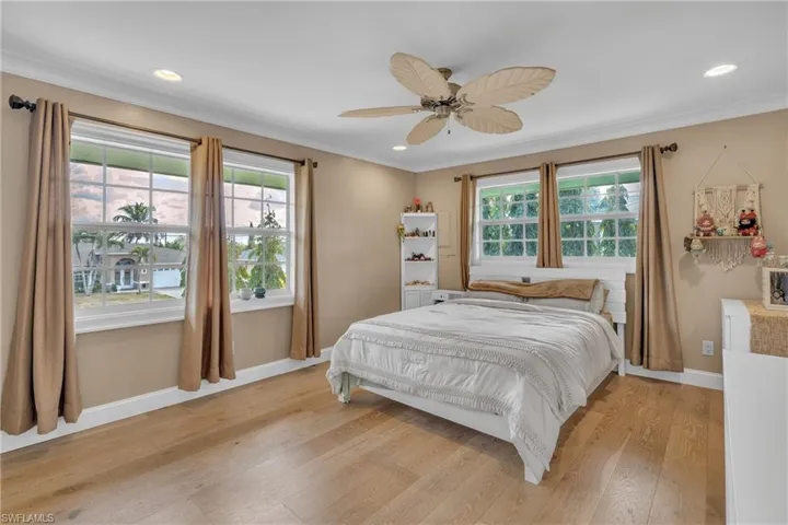 Bedroom with light wood-style floors, a ceiling fan, recessed lighting, and crown molding