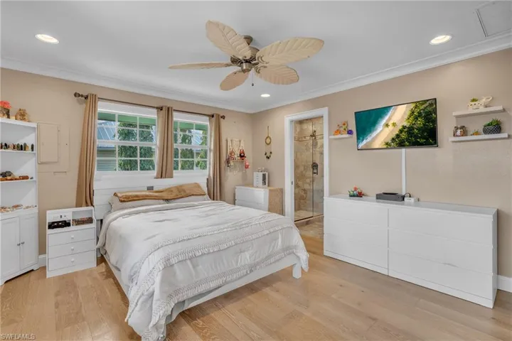 Bedroom with light wood-style flooring, a ceiling fan, crown molding, and recessed lighting