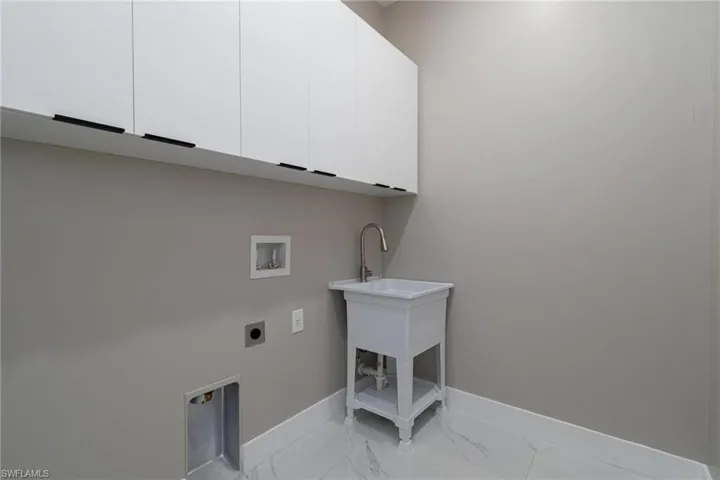 Laundry room with electric dryer hookup, washer hookup, and cabinets