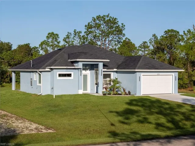 View of front of property with a front lawn and a garage