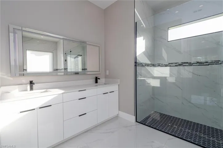 Bathroom featuring vanity and tiled shower