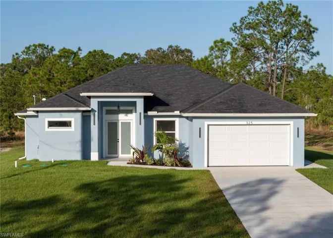 Ranch-style home with a front lawn and a garage