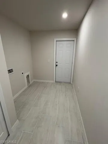 Washroom featuring hookup for an electric dryer, hookup for a washing machine, and light hardwood / wood-style floors