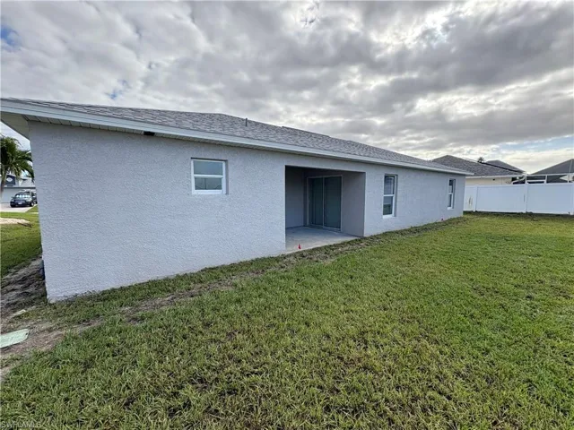 Back of property with a lawn and a patio area