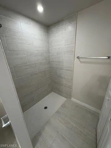 Bathroom with a tile shower and tile patterned floors