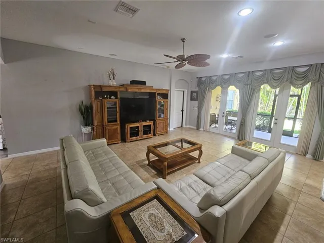 Spacious living area featuring large format tile flooring, recessed lighting, and a ceiling fan