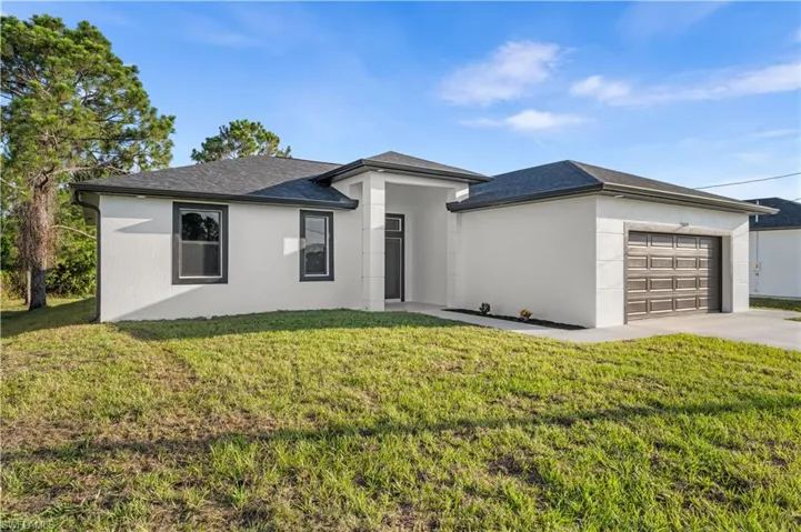 View of front of property featuring a garage and a front yard