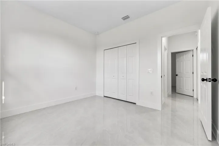 Unfurnished bedroom featuring a closet and light tile floors