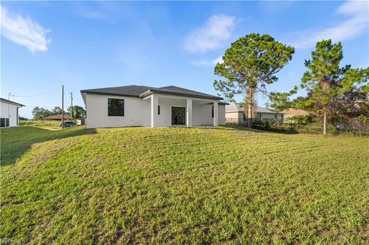 Rear view of property with a lawn