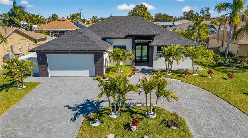 View of front facade featuring roof with shingles, french doors, a front lawn, stucco siding, and a residential view