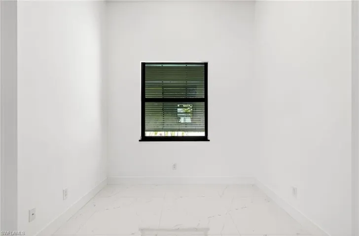 Empty room with baseboards and light marble finish floors