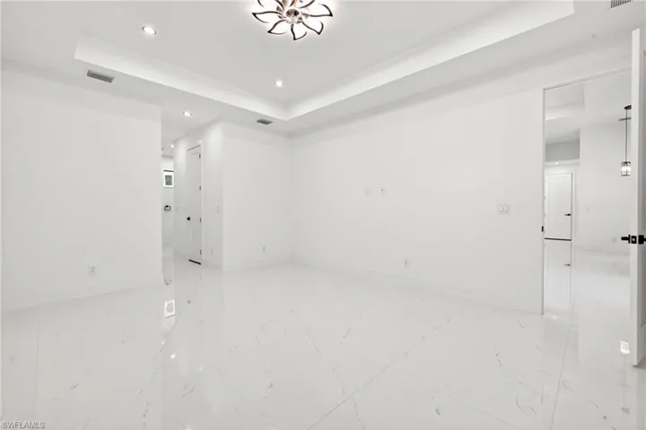Spare room with a tray ceiling and recessed lighting