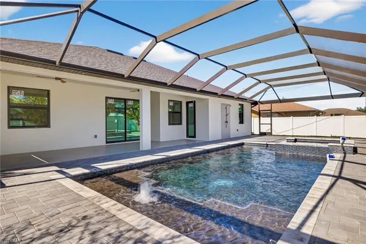 Relaxing pool / spa with a sunroom, glass enclosure, and a patio