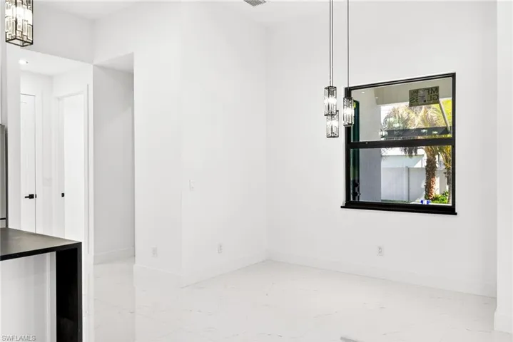 Unfurnished dining area with light marble finish flooring and hanging lights