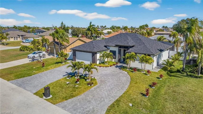 View of front of house featuring a front lawn, decorative driveway, stucco siding, an attached garage, and a shingled roof