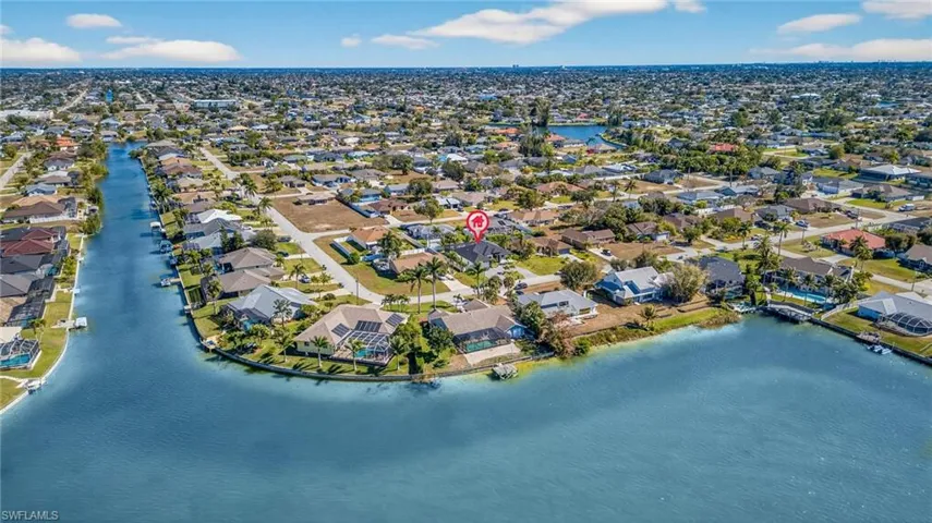 Aerial view of property and surrounding area with a nearby body of water and nearby suburban area